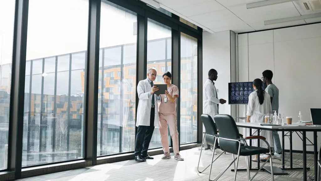 Equipo de salud revisa una tableta y estudios de imagen en una clínica