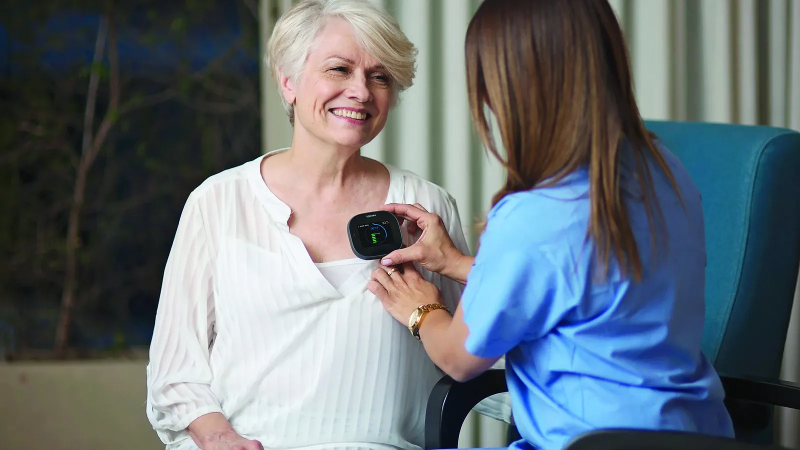 Una profesional utiliza TytoCare para auscultar a una paciente adulta.