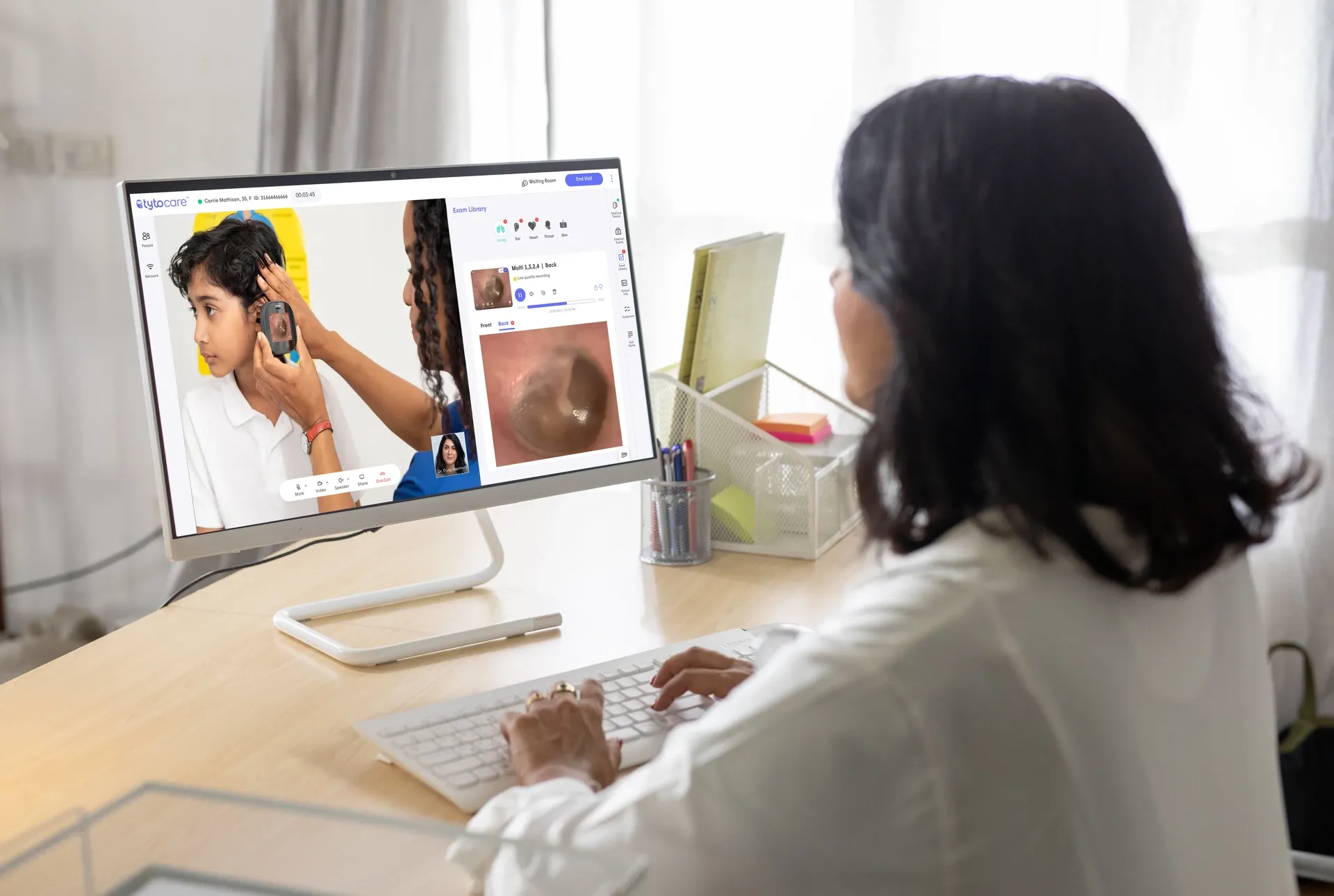 Médica revisa en una pantalla la captura de un examen de oído realizado a distancia con TytoCare.