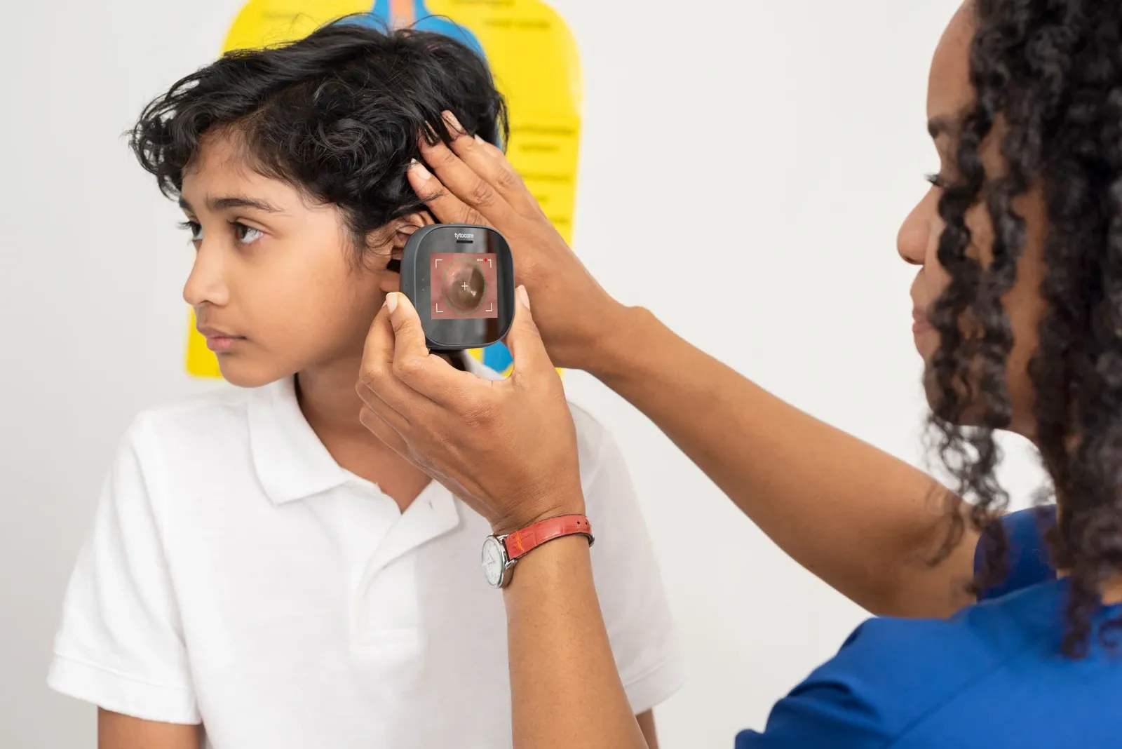 Cuidadora realiza un examen de oído a un niño con TytoCare