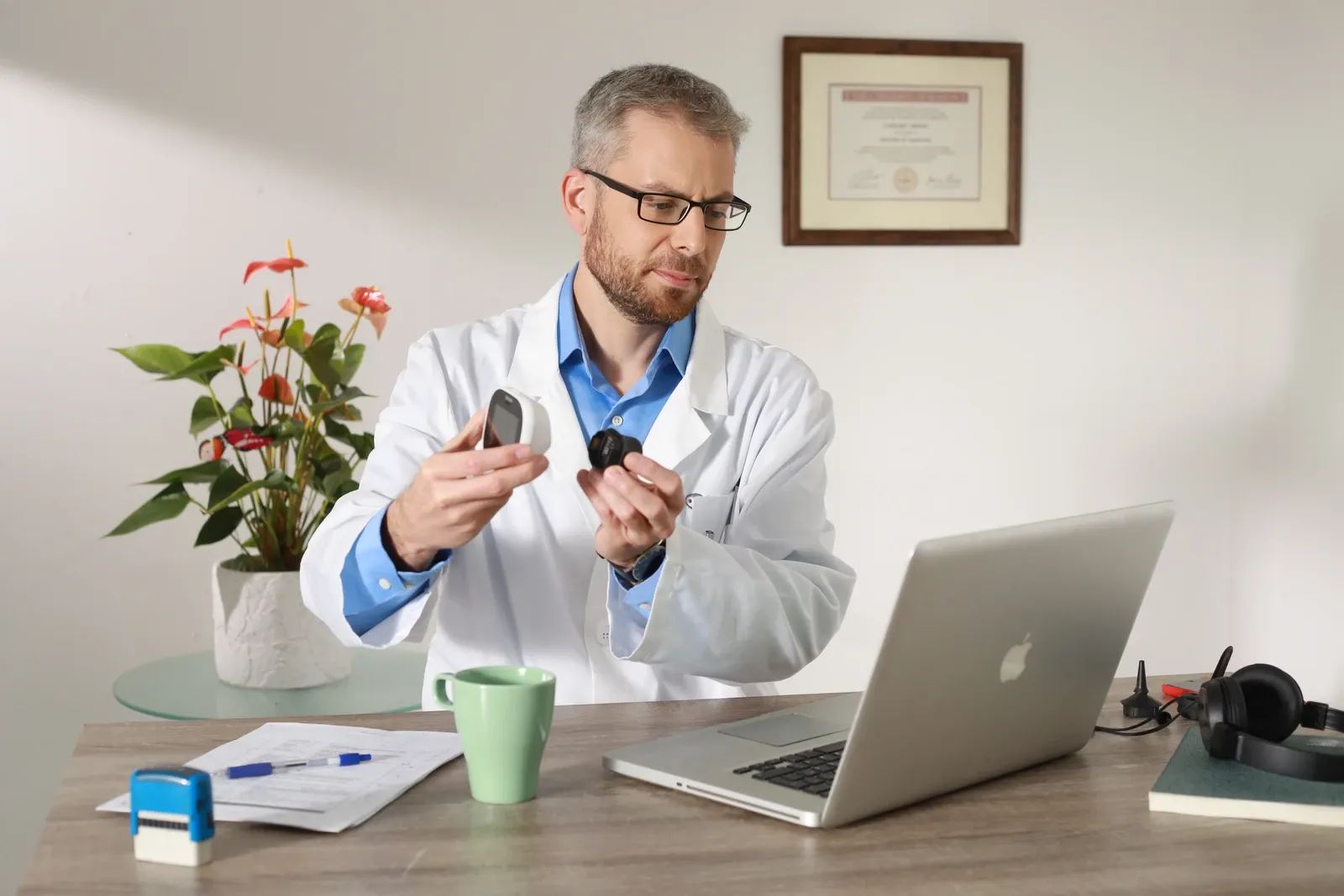 Médico revisa el dispositivo TytoCare junto a su computadora