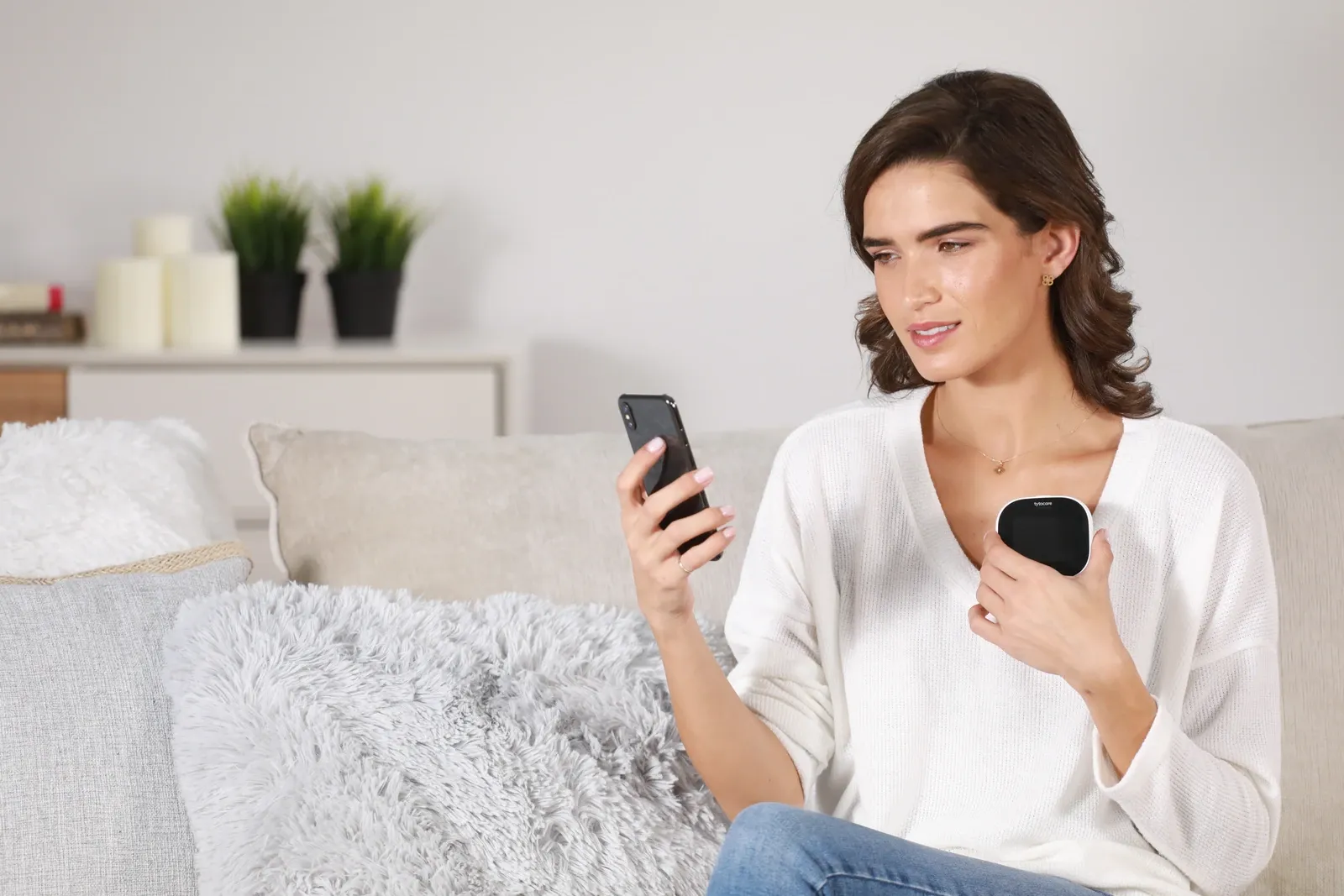 Mujer utiliza TytoCare mientras consulta su teléfono