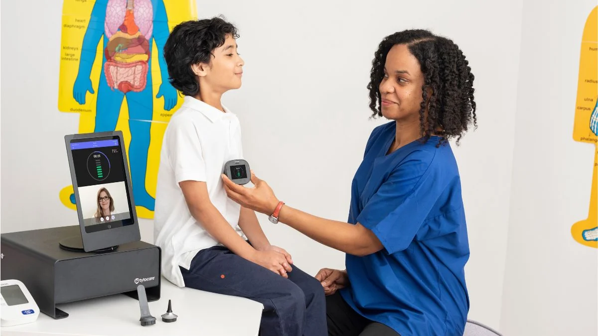 Profesional de salud examinando a un estudiante con una estación TytoCare