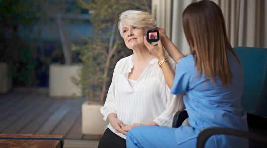 Enfermera realizando examen médico remoto a adulto mayor en domicilio con TytoCare